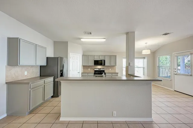 a kitchen with stainless steel appliances a refrigerator sink and cabinets
