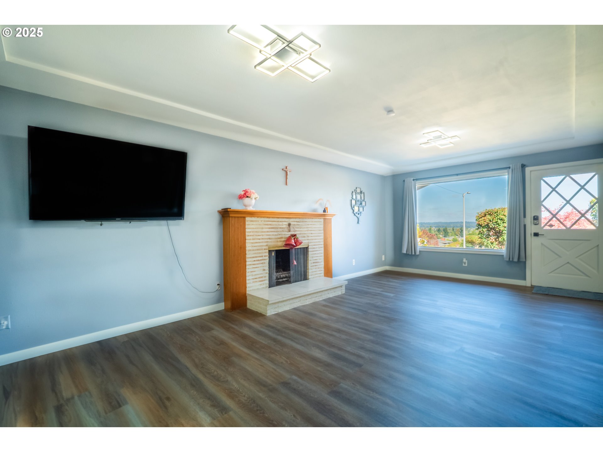 11910 Northeast Fremont Street Portland, OR 97220 - Photo 5 of 23 a view of an empty room with a fireplace and a flat screen tv