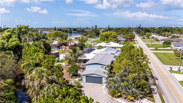 an aerial view of residential houses with outdoor space and trees