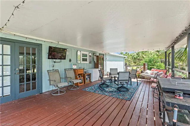 a living room with furniture a flat screen tv and a floor to ceiling window