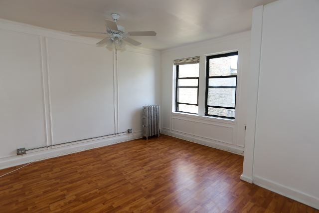 4735 North Beacon Street, Unit 411 Chicago, IL 60640 - Photo 5 of 11 a view of an empty room with a window and wooden floor
