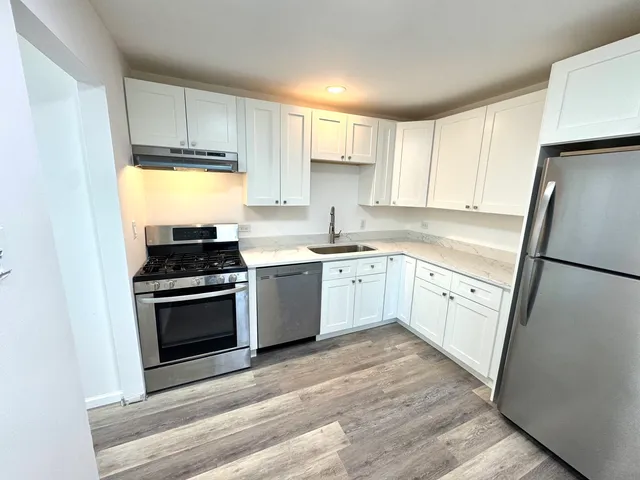 a kitchen with white cabinets and white appliances