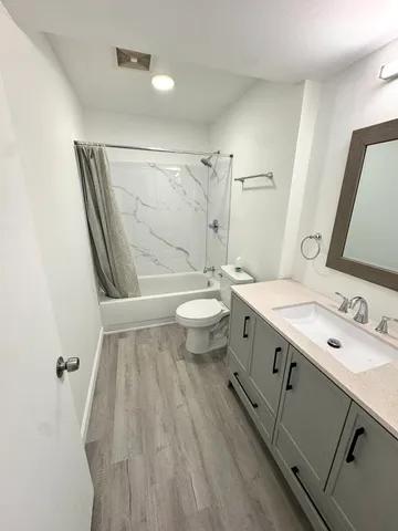 a bathroom with a double vanity sink toilet and mirror