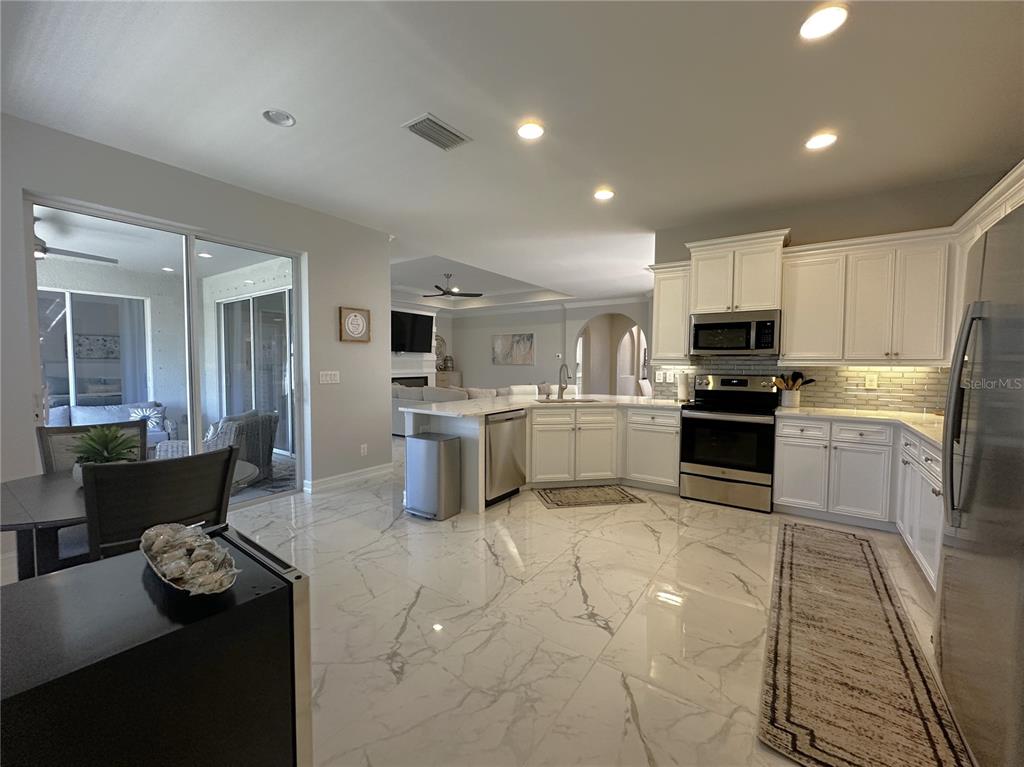 25191 Keygrass Court Punta Gorda, FL 33955 - Photo 15 of 66 a kitchen with furniture a refrigerator and a stove top oven