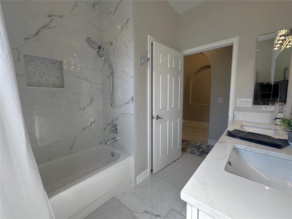 25191 Keygrass Court Punta Gorda, FL 33955 - Photo 30 of 66 a bathroom with a tub a sink and a large mirror