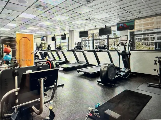 a gym room with furniture and a chandelier
