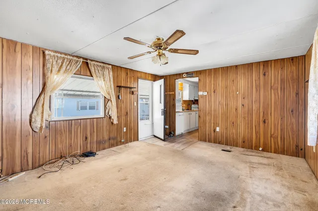 a view of a livingroom with a chandelier fan wooden floor and a ceiling fan