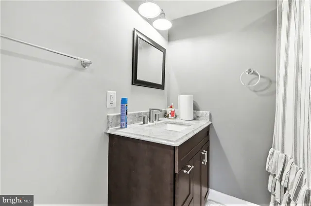 a bathroom with a granite countertop sink and a mirror