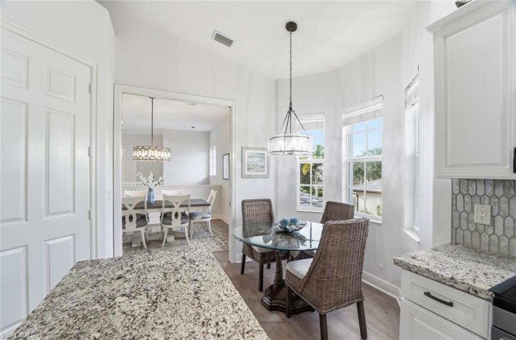 7842 Hawthorne Drive, Unit 1703 Naples, FL 34113 - Photo 16 of 31 a view of a dining room and livingroom with furniture wooden floor a chandelier