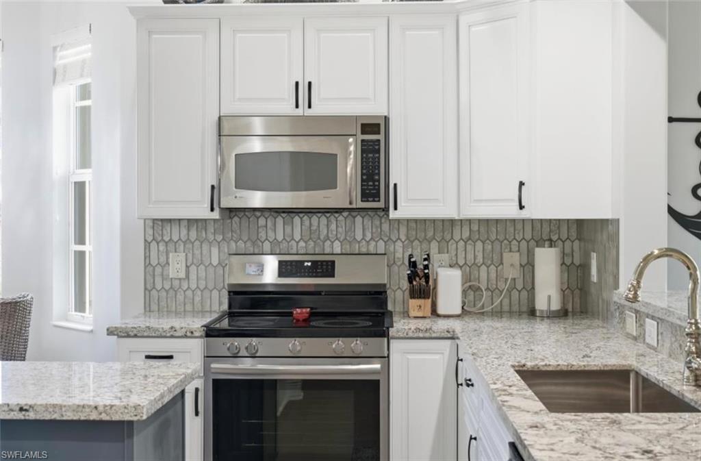 7842 Hawthorne Drive, Unit 1703 Naples, FL 34113 - Photo 17 of 31 a kitchen with stainless steel appliances granite countertop a stove and a sink