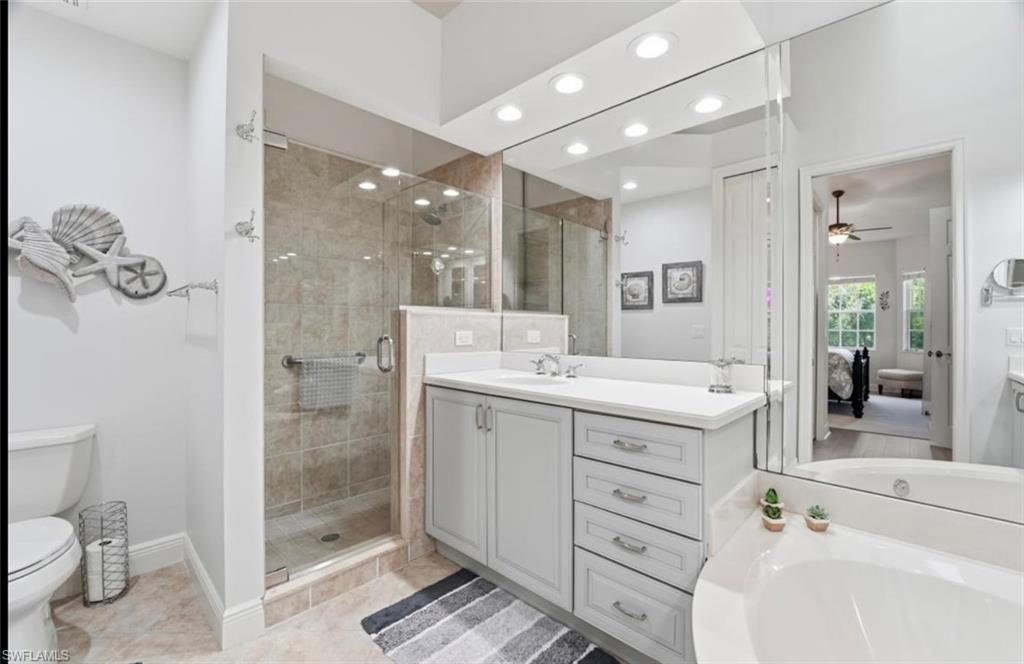 7842 Hawthorne Drive, Unit 1703 Naples, FL 34113 - Photo 26 of 31 a bathroom with a double vanity sink toilet and shower