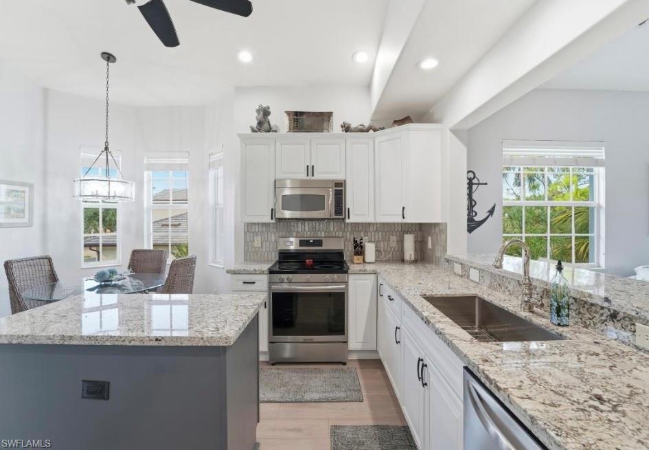 7842 Hawthorne Drive, Unit 1703 Naples, FL 34113 - Photo 5 of 31 a kitchen with granite countertop a sink a counter top space appliances and cabinets