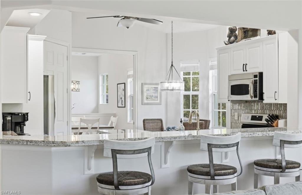 7842 Hawthorne Drive, Unit 1703 Naples, FL 34113 - Photo 6 of 31 a kitchen with a table and chairs