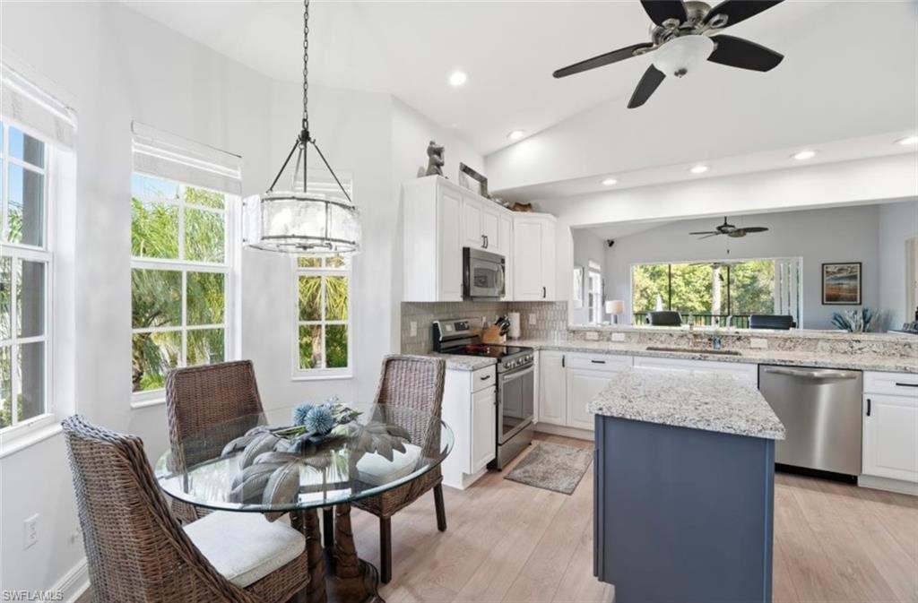7842 Hawthorne Drive, Unit 1703 Naples, FL 34113 - Photo 9 of 31 a kitchen with a table chairs stove and refrigerator