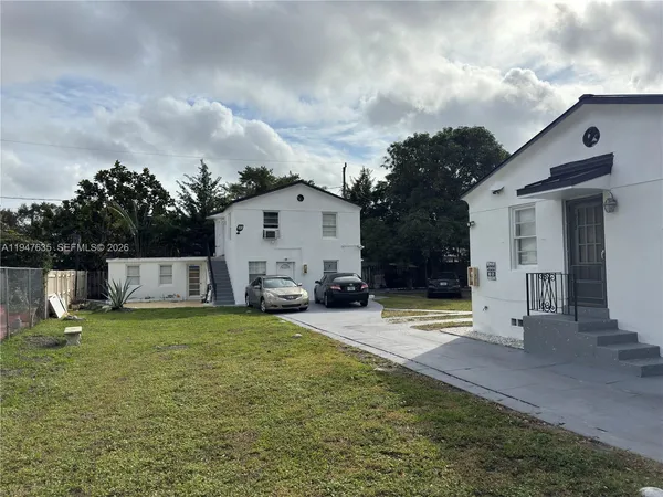 a view of a house with backyard and sitting area