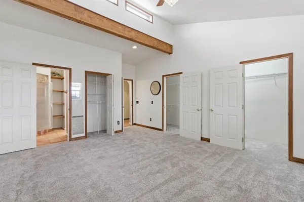 an empty room with closet and mirrors