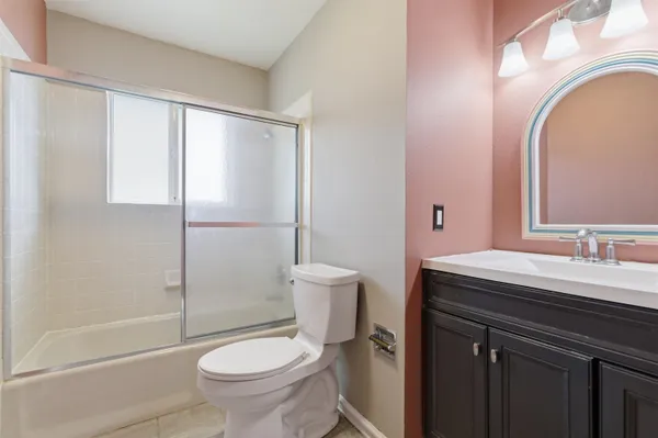 a bathroom with a granite countertop toilet a sink and a mirror