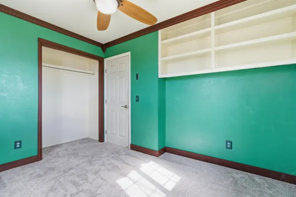 an empty room with a window and a ceiling fan