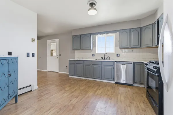 a kitchen with stainless steel appliances a sink cabinets and wooden floor