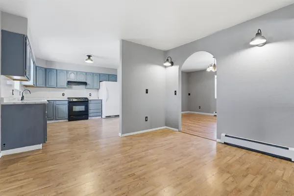 a large kitchen with cabinets and wooden floor