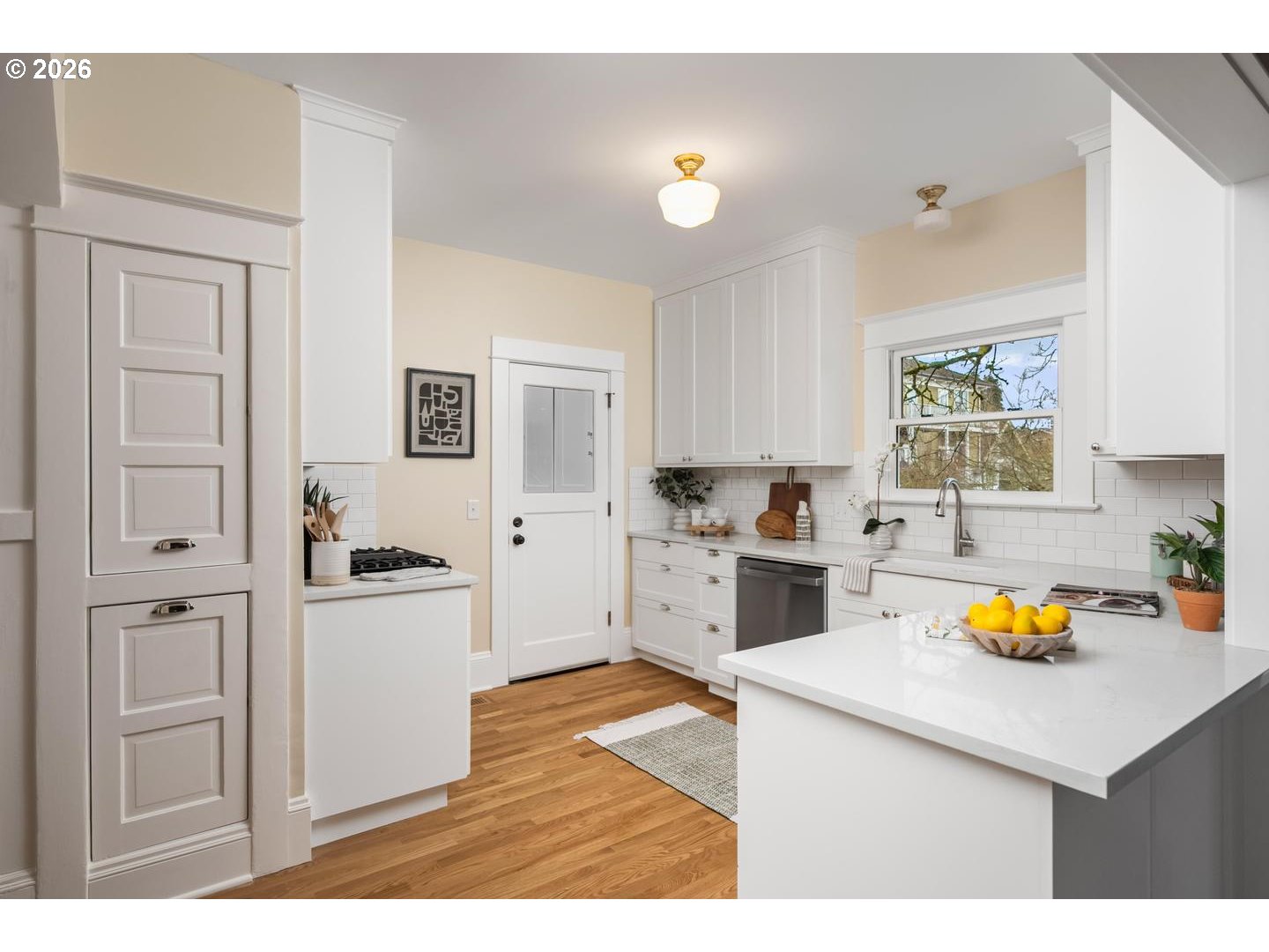 1239 Northeast Sumner Street Portland, OR 97211 - Photo 14 of 48 a kitchen with stainless steel appliances a white refrigerator a stove a sink and white cabinets with wooden floor