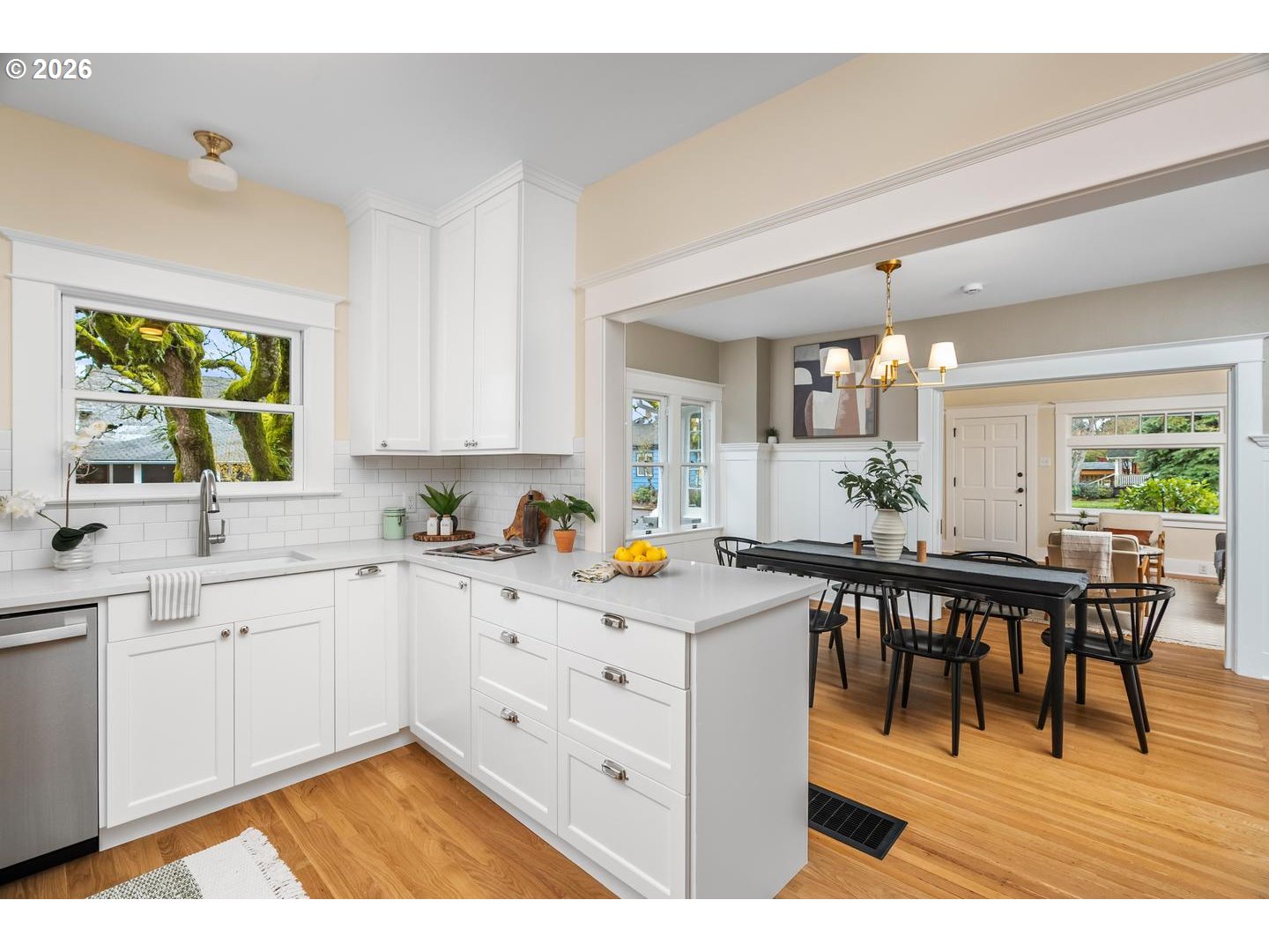 1239 Northeast Sumner Street Portland, OR 97211 - Photo 17 of 48 a kitchen with white cabinets and dining table