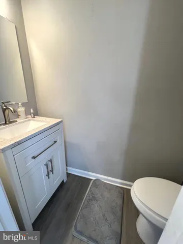 a bathroom with a granite countertop toilet and a sink
