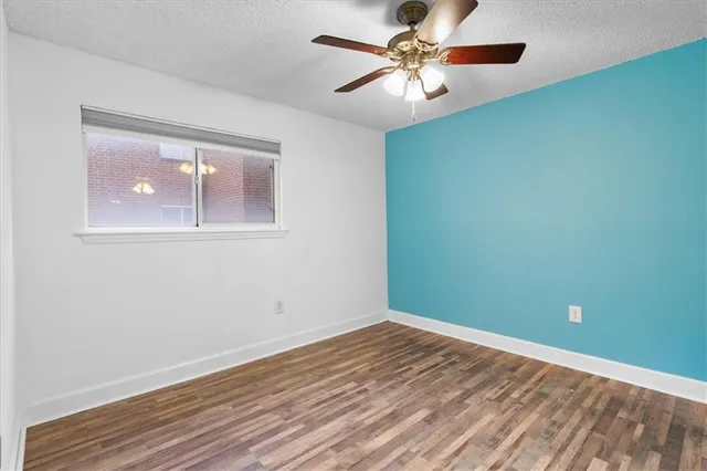 an empty room with a window and a fan
