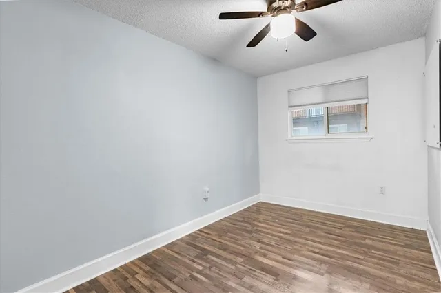 a view of an empty room with a window and a ceiling fan