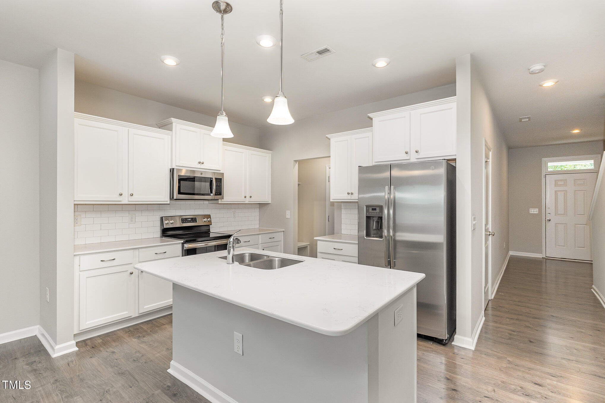 3607 Water Mist Lane Raleigh, NC 27604 - Photo 13 of 30 a kitchen with stainless steel appliances a stove a sink a refrigerator cabinets and chairs