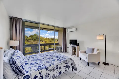 a bedroom with a bed and large windows