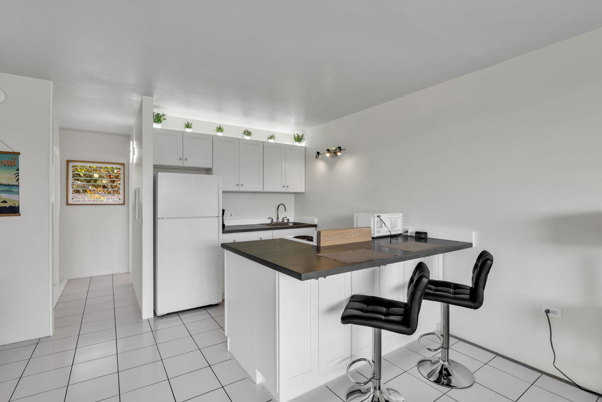 120 Hui Rd F, Unit E16 Lahaina, HI 96761 - Photo 7 of 22 a kitchen with stainless steel appliances kitchen island granite countertop a sink and a refrigerator