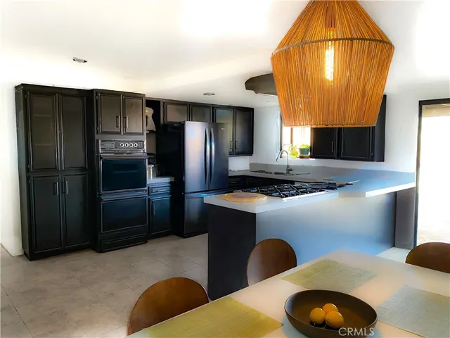 a kitchen with stainless steel appliances granite countertop a refrigerator a stove and a sink