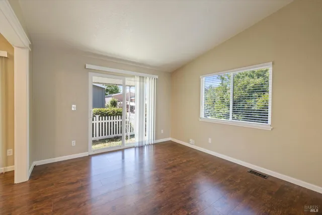 a view of a room with wooden floor and a window