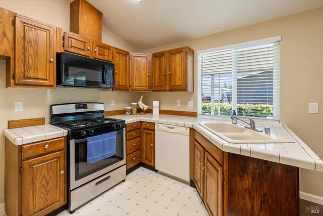 a kitchen with stainless steel appliances granite countertop a sink stove and microwave