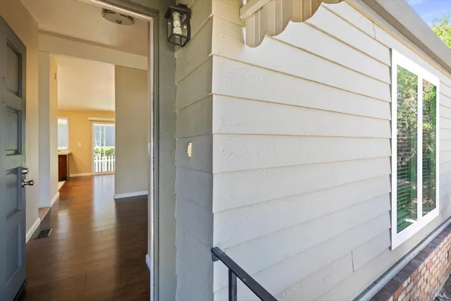 a view of a hallway with wooden floor and a bathroom