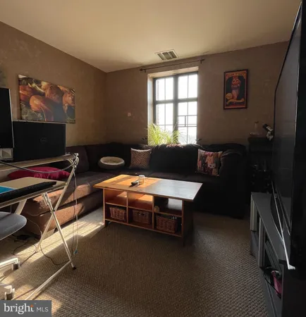a living room with furniture a flat screen tv and a window