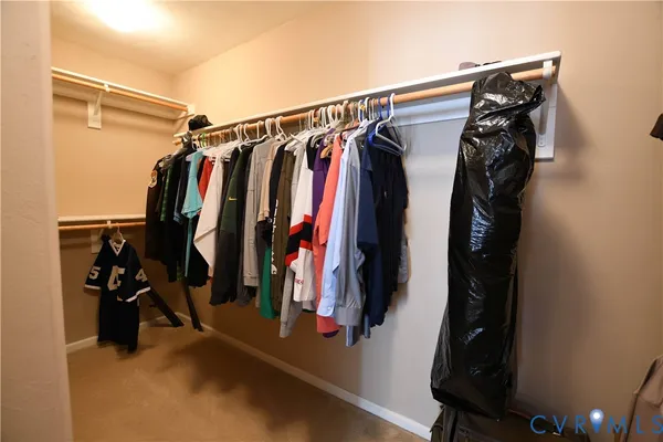 a view of walk in closet with clothes and shoes