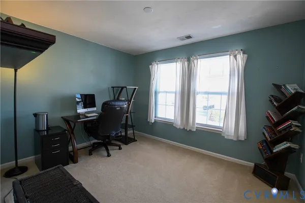 a view of a workspace with furniture and a window