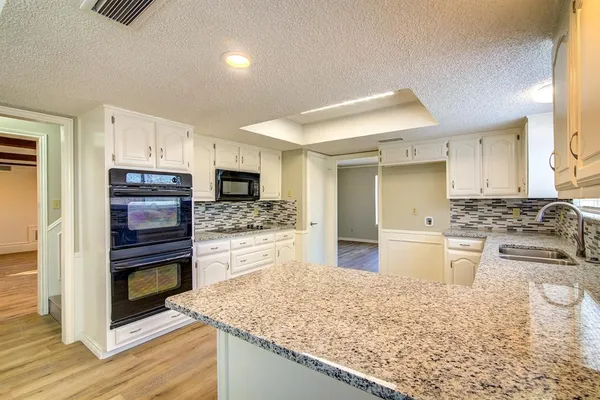 a kitchen with stainless steel appliances kitchen island granite countertop a stove top oven and sink