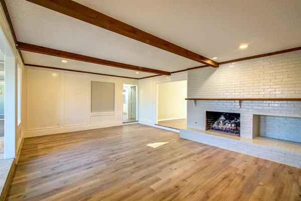 a view of an empty room with a window and fireplace