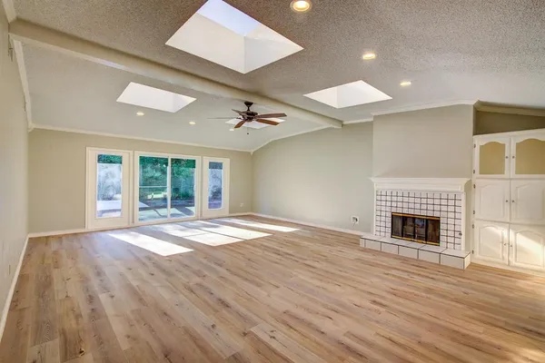 an empty room with wooden floor and fireplace