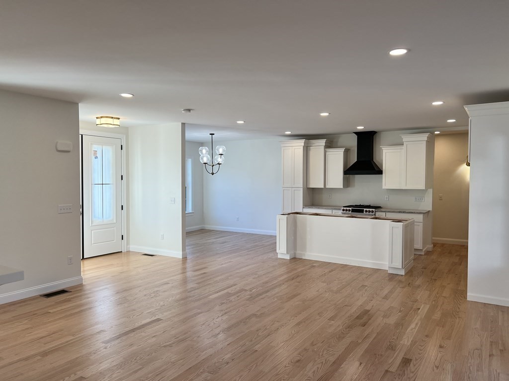 109 Mulpus Road, Unit LOT 1 Lunenburg, MA 01462 - Photo 18 of 39 a large kitchen with stainless steel appliances kitchen island wooden floors and white cabinets