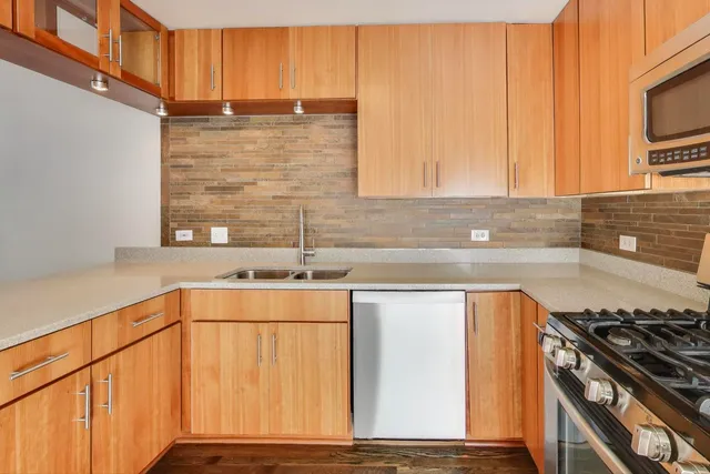 a kitchen with stainless steel appliances granite countertop a sink stove and cabinets
