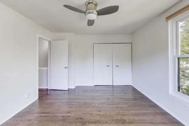 an empty room with wooden floor and closet