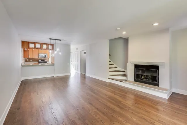 a view of a room wooden floor fire place and windows