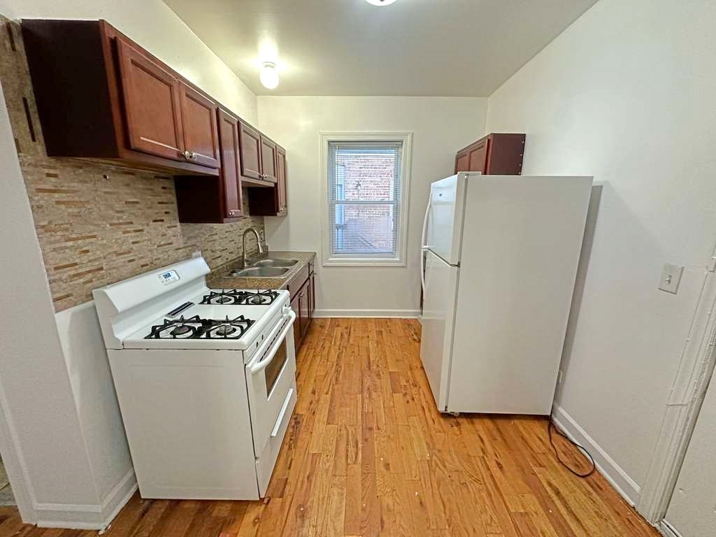 5145 West Ferdinand Street, Unit 2 Chicago, IL 60644 - Photo 12 of 13 a kitchen with a stove a refrigerator and a wooden floor