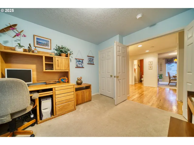 a kitchen with stainless steel appliances granite countertop a dining table chairs and a refrigerator