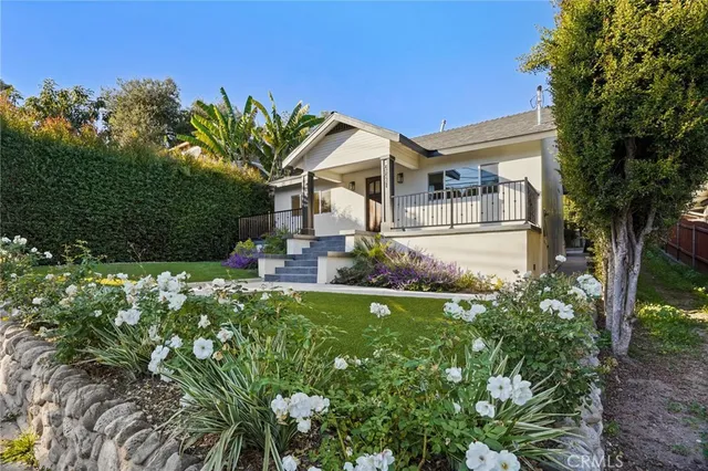 a front view of a house with a garden