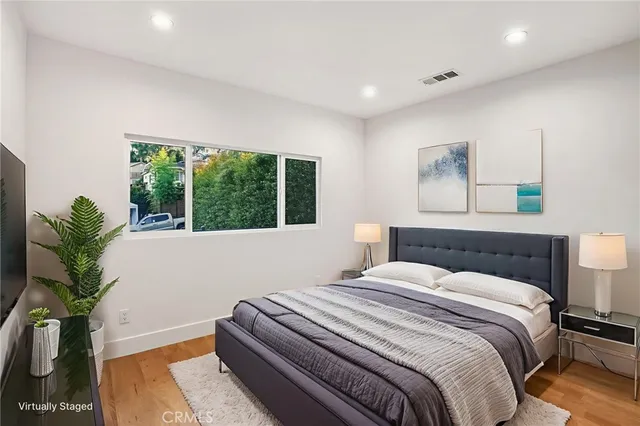 a bedroom with a large bed and a potted plant
